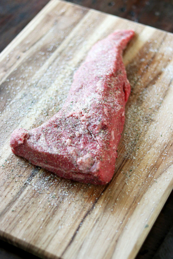 garlic salt seasoned tri-tip steak on a cutting board